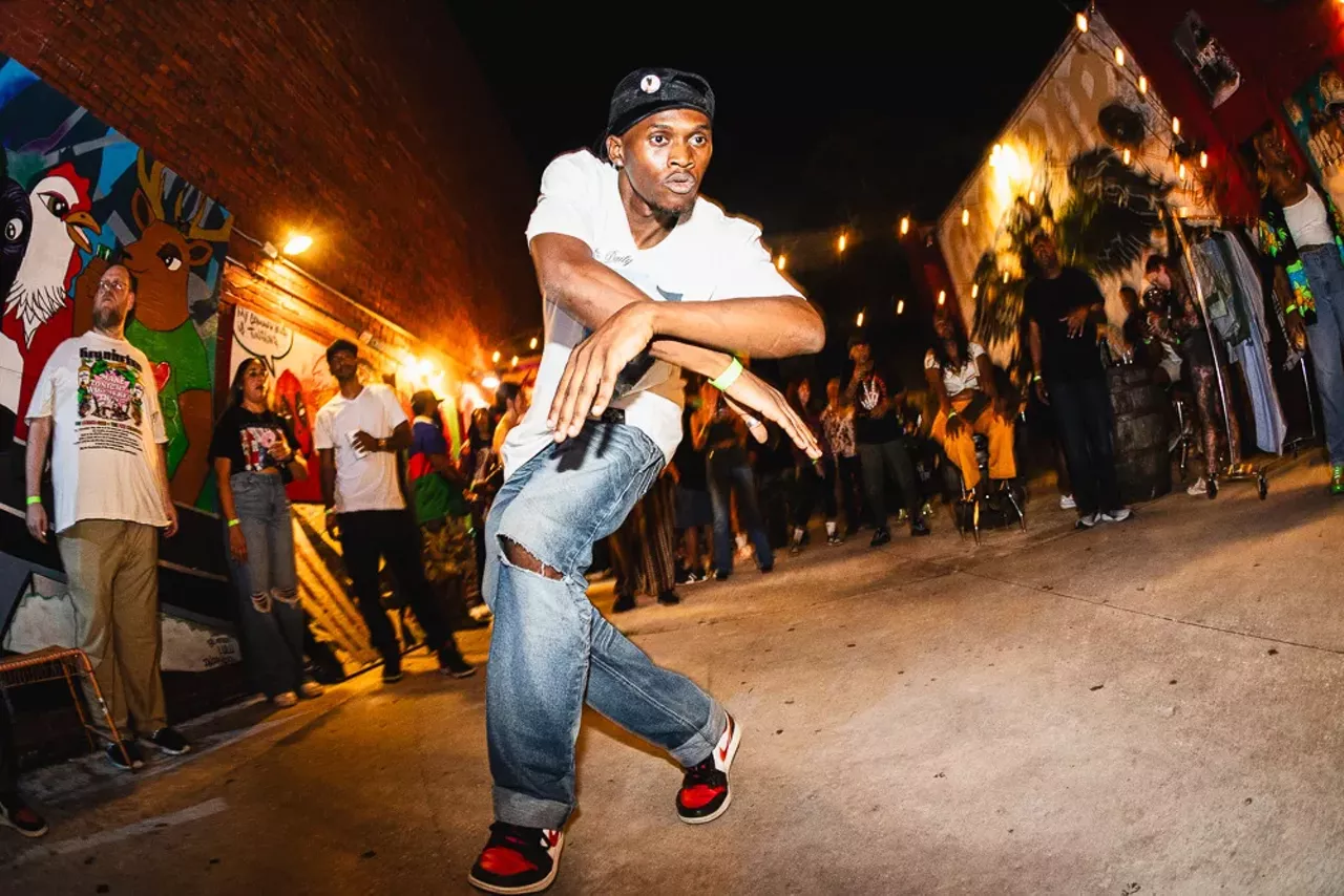 Man in white tshirt and jeans dancing in the Crowbar courtyard